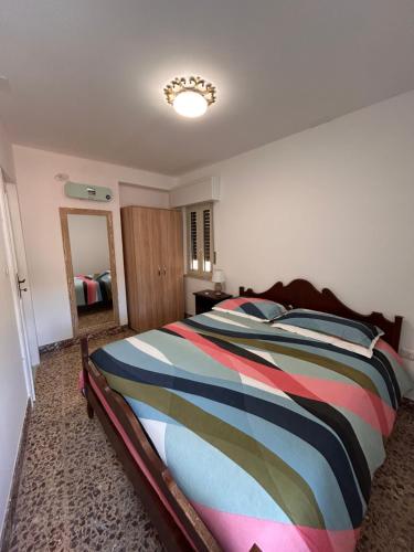 a bedroom with a bed with a colorful striped comforter at Villa Sole in Randazzo