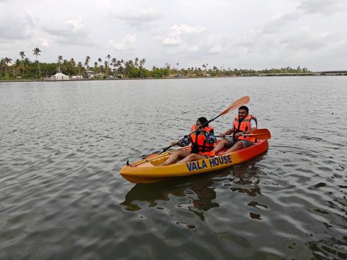 two people in a kayak on a body of water at Vala House in Cherai Beach