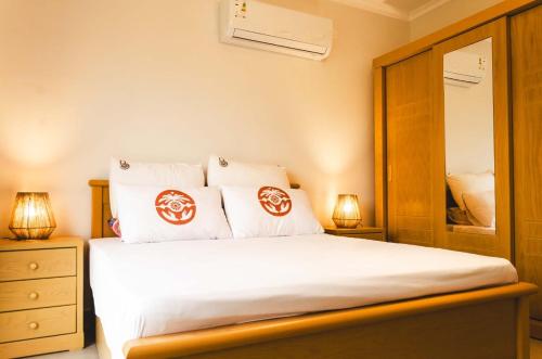 a bedroom with a bed with two lamps and a mirror at Gaia North Coast Ras El Hekma in Zāwiyat al ‘Awwāmah