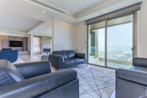 a living room with couches and a large window at Moonlight 2BR In Ain Saade in Beit Meri