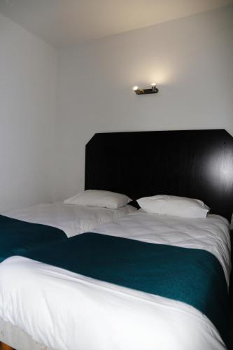 a bedroom with a large bed with a black headboard at Audotel in Carcassonne