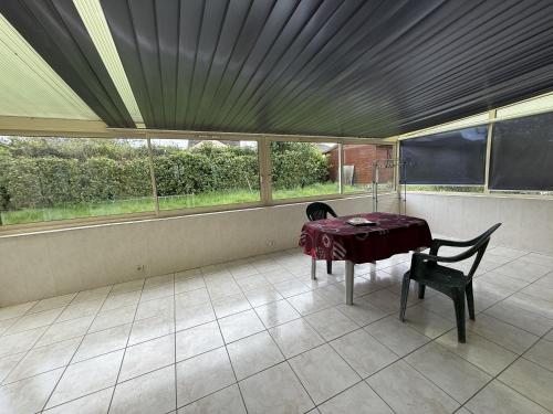 a dining room with a table and chairs and windows at Le Plain Pied - Circuit - Rêve au Mans in Marigné-Laillé