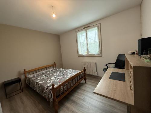 a bedroom with a bed and a desk and a window at Le Plain Pied - Circuit - Rêve au Mans in Marigné-Laillé