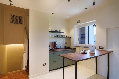 a kitchen with a wooden table in a room at Uefio - Boutique Stay in Bacoli