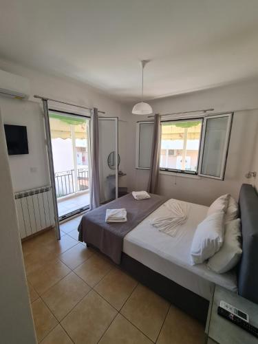 a bedroom with a large bed and two windows at The Hammam Guest House in Nydri