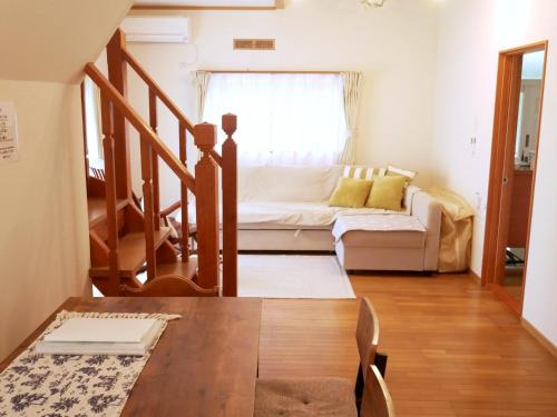 a living room with a couch and a table at Villa Metasequoia 愛犬と泊まれる宿 in Kaizu