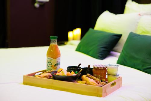 un plateau de nourriture et de boissons sur un lit dans l'établissement Love Room Marseille - Aphrodisia, à Marseille