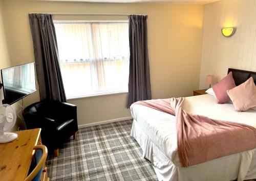 a hotel room with a bed and a window at The Oakland Hotel in Woodham Ferrers