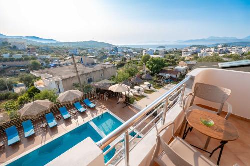 a balcony with a swimming pool and patio furniture at Vila Shpetimi in Ksamil