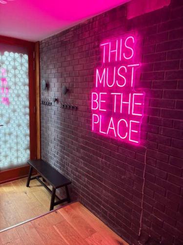 a neon sign that says this must be the place at Luxury Canal St Villa with Free Parking in Manchester