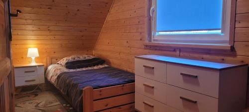 a small bedroom with a bed and a window at Niebieski Zakątek in Wisełka