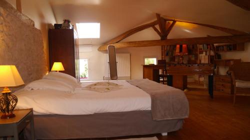 a bedroom with a large white bed and a piano at Gîte du Corupsis in Villeneuve-sur-Lot