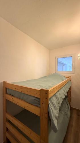 Ce lit superposé en bois se trouve dans un dortoir doté d'une fenêtre. dans l'établissement Beach cabin studio, à Argelès-sur-Mer