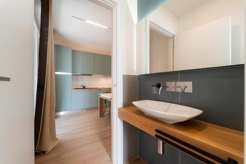 a bathroom with a white sink on a wooden counter at Appartamento incantevole fronte mare 1-2-3B in Villa Rosa
