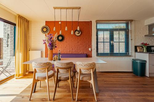 a kitchen with a table and chairs in a room at Groenendijk Verhuur Zomerhof 2 in Ouddorp
