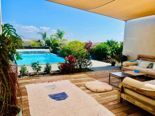a living room with a view of a swimming pool at Golden Wave Villa Lajares in Lajares
