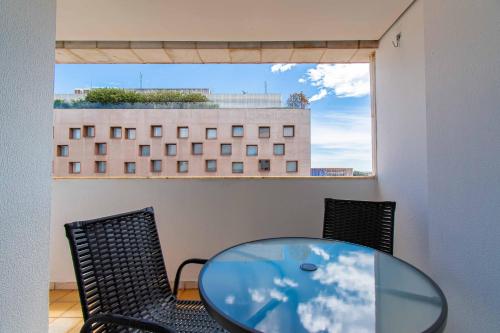 a glass table and chairs in a room with a window at BSB STAY Torre Flats Particulares - Mercure Líder in Brasilia