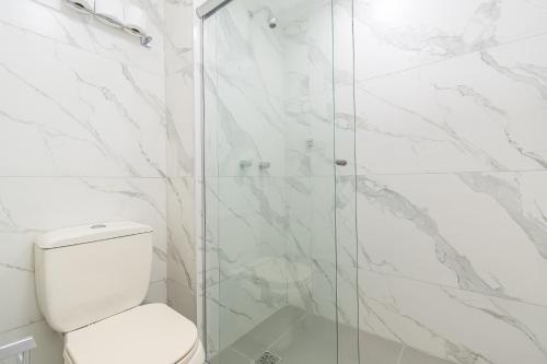 a bathroom with a toilet and a glass shower at BSB STAY Torre Flats Particulares - Mercure Líder in Brasilia