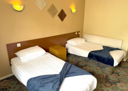 a hotel room with three beds in a room at The Oakland Hotel in Woodham Ferrers