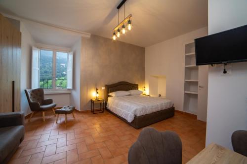 a bedroom with a bed and a tv and a couch at Vicolo del Pozzo Suite in Spoleto