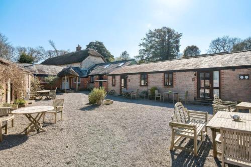 a courtyard with tables and chairs and a building at Berehayes Cottages in Whitchurch Canonicorum