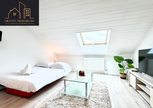 a white bedroom with a bed and a skylight at Le Chaleureux in Marignier
