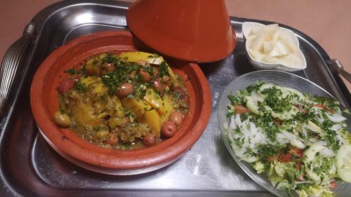 un plateau avec une assiette de nourriture et un bol de nourriture dans l'établissement maison noé , residence al quaria ab40, à Marrakech