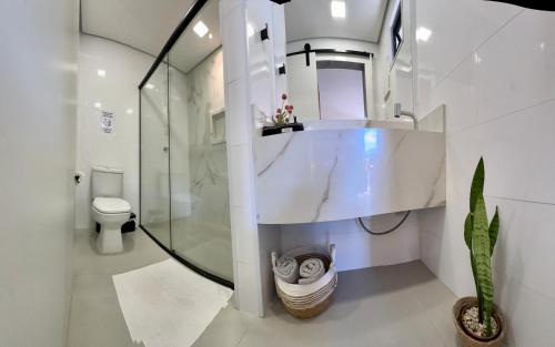 a bathroom with a sink and a shower and a toilet at Loft para Casal em Bombinhas - Sem Garagem in Bombinhas