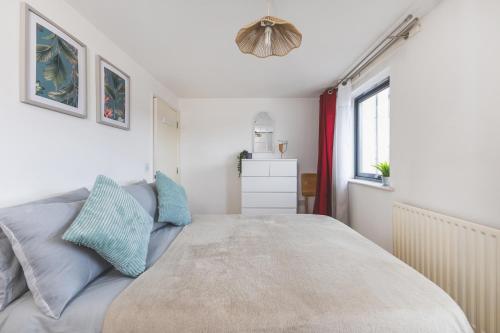 a bedroom with a large bed with blue pillows at Spacious Wembley Flat Comfy Beds 2 Baths in London