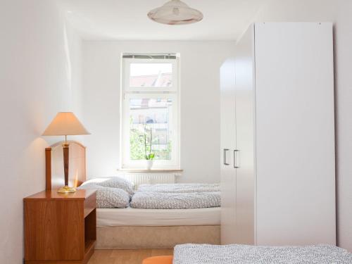 1 dormitorio con 2 camas y ventana en Ferienwohnung Leipzig Nord-Ost, en Leipzig