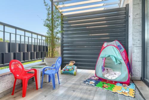 a patio with chairs and a table and a fence at Vision apartmani Vrnjačka Banja in Vrnjačka Banja