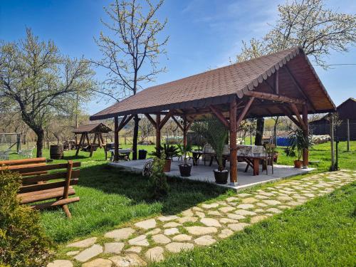 a pavilion with a table and benches in a park at Pensiunea Cocoș in Spulber