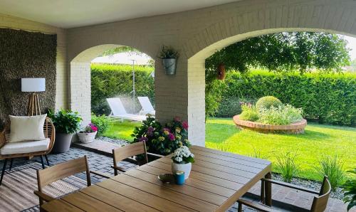 an outdoor patio with a wooden table and chairs at Monferrato Country House Basin dAmor Casa di campagna in Asti