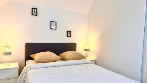 une chambre avec un lit avec trois tableaux au mur dans l'établissement Beautiful house 8min to Disneyland, à Magny-le-Hongre