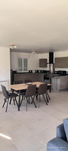 une salle à manger avec une table et des chaises en bois dans l'établissement Gîte Terre et Mer, 