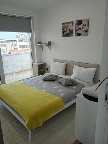a bedroom with a large bed with a yellow blanket at Zen aeroport in Sînnicoară