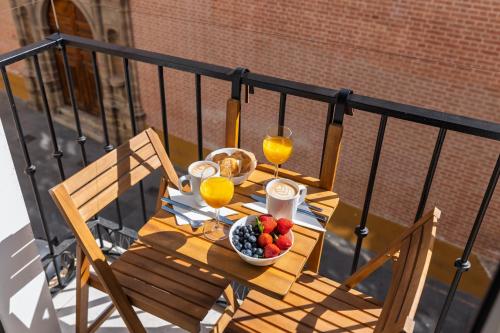 stół z miską owoców i dwa kieliszki soku pomarańczowego w obiekcie Central and Spacious Apartment with Parking on-site w Maladze