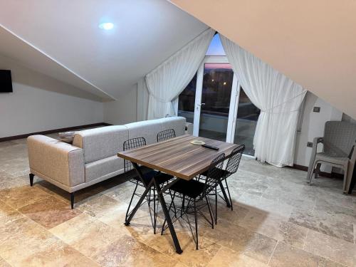 a living room with a couch and a table and chairs at Avanos Ertaş Konukevi in Avanos