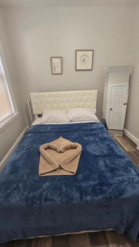 a bed with a blue blanket and a robe on it at Serenity Haven in Irvington