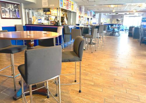 a restaurant with tables and chairs and a bar at The Oakland Hotel in Woodham Ferrers