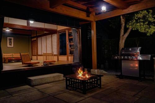 a patio at night with a table and a stove at 旧邸貸別荘 南壽庵 in Tateyama