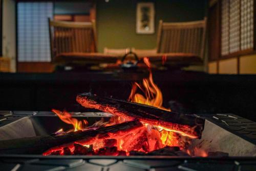 a fire pit with flames in a room at 旧邸貸別荘 南壽庵 in Tateyama