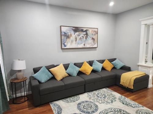 a living room with a gray couch with colorful pillows at Summer Sunset Hideout 1-2 Bedrooms and 1 Bath in Atlantic City