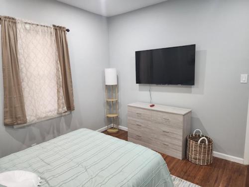 a bedroom with a bed and a flat screen tv at Summer Sunset Hideout 1-2 Bedrooms and 1 Bath in Atlantic City