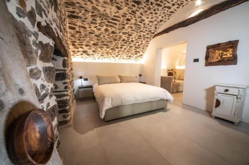 a bedroom with a bed and a stone wall at Porta Bormina Loft&Suites in Tirano