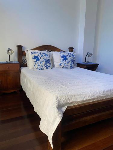 a bedroom with a bed with blue and white pillows at Casa Hotel Jardin Azul in Cali