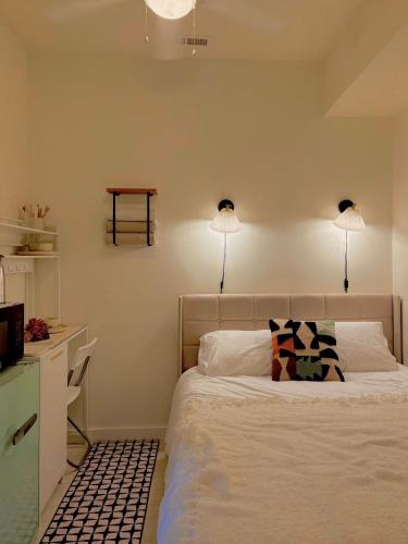 a bedroom with a bed with two lights on the wall at Sattva Home in Charlottesville