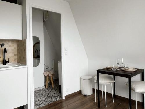 d'une salle à manger avec une table et des murs blancs. dans l'établissement Studio à 5 minutes de la mer - Blonville-sur-mer, à Blonville-sur-Mer