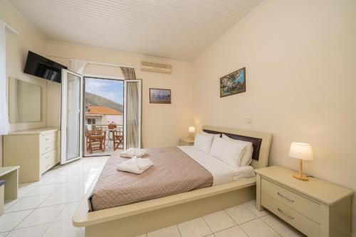 a bedroom with a bed and a balcony at MAKIS VILLAGE-APARTMENTS in Ayia Evfimia