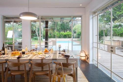 a dining room with a large wooden table and chairs at Carmelo Keren Villa in Kesar Shenaryahu